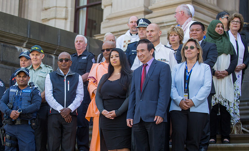 Commissioners and multifaith leaders standing on the steps of Parliament House