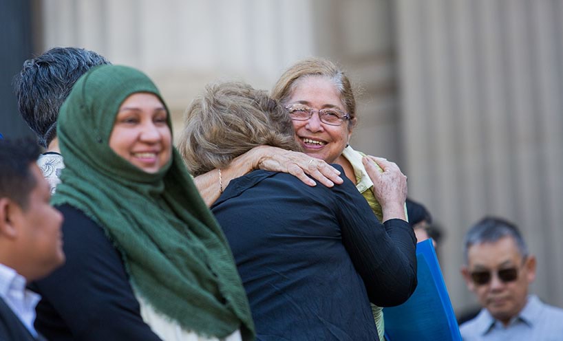 Multifaith leaders embrace on the steps of Parliament House